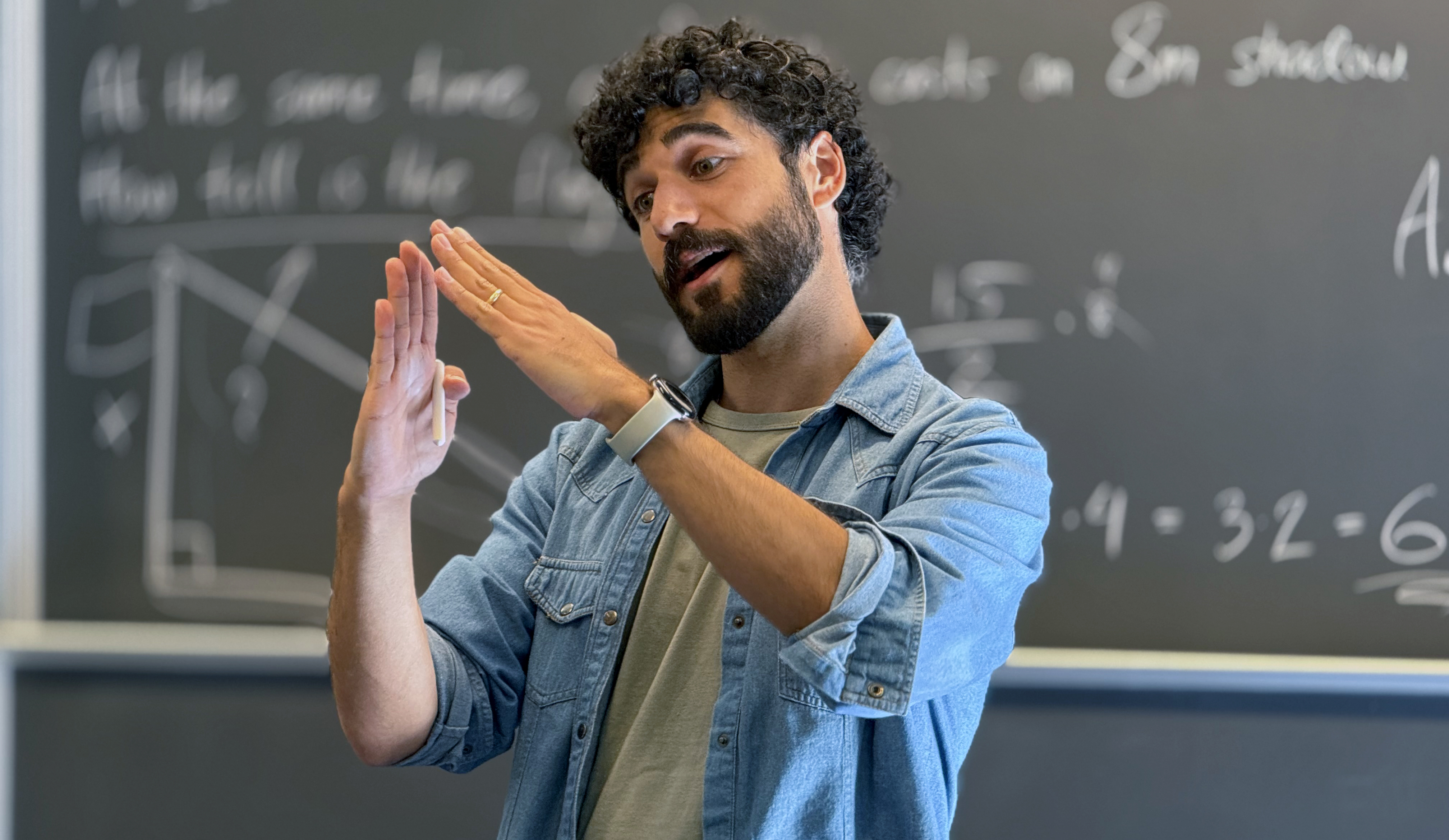 Jonatan Kara using both hands to explain a relationship a second way