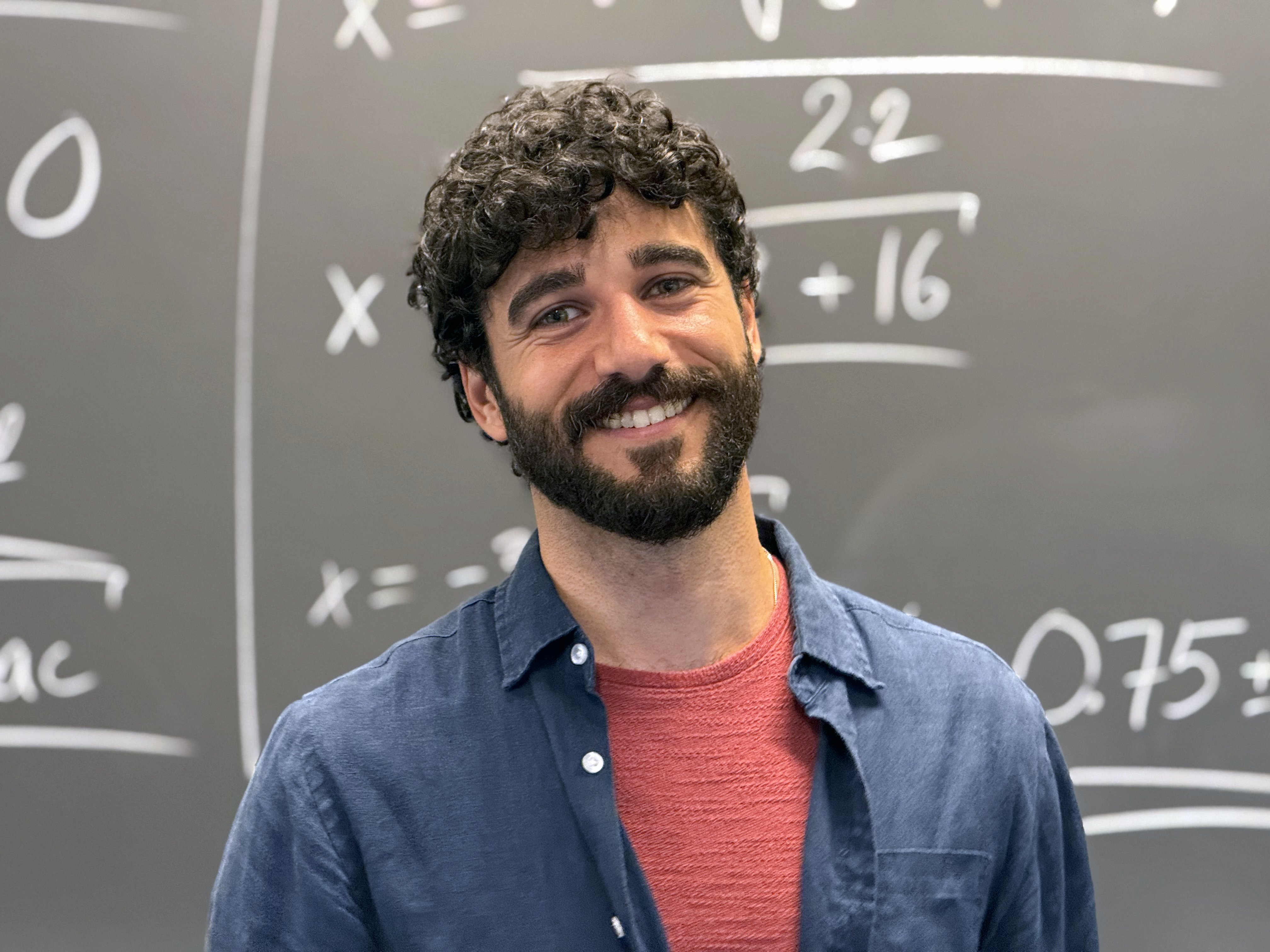 Jonatan Kara, mathematics teacher, in front of a blackboard of quadratic working